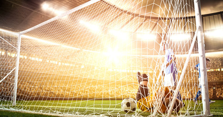 Intense soccer moment in front of the goal on the professional soccer stadium.