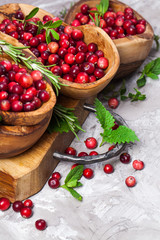 Harvest fresh red cranberries in wooden bowl, selective focus. Autumn concept