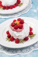 Meringue pavlova cake with whipped cream and fresh raspberries