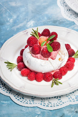 Meringue pavlova cake with whipped cream and fresh raspberries