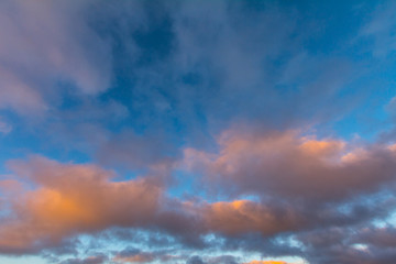 The clouds in the sky are colored by the sun at dawn.