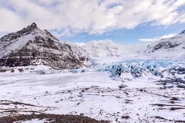 Fototapeta na wymiar Vast Icelandic mountainous landscape, with turquoise glacier and glacial moraine