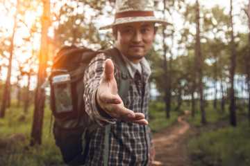 hiker with backpack lending a helping hand in forest
