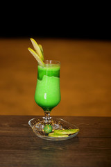 A glass of sour apple juice with fresh apple cuts