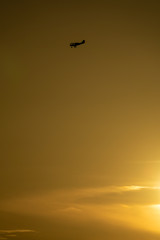 Profile of light aircraft against orange sky