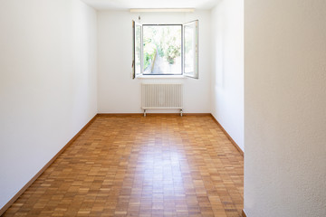 Empty room with window and parquet