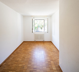 Empty room with window and parquet
