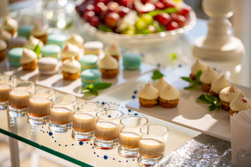 Creamy coffee liqueur with caramel on a table on the background of cakes