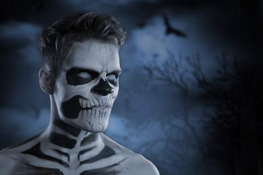 Skull make up portrait of young man. Zombies on Halloween