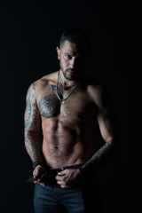 Fototapeta na wymiar Fashion model buckle leather belt in jeans. Man with tattoo design on skin. Bearded man shirtless with fit torso. Sportsman with six pack and ab. Fitness with sport and bodycare