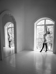 Beautiful young girl dancing in the Studio by the window and mirror