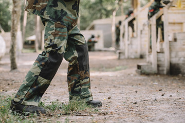 cropped image of paintball player wearing camouflage uniform outdoors