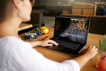Freelancer video editor works at the laptop computer with movie editing software. Videographer...