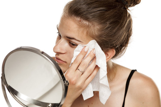 Young Woman Cleaning Her Face With Wet Wipe On White Background