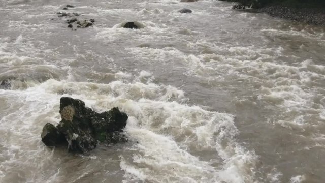 Aerial slow motion shot of a river in flood. The Rio Abanico on the Amazonian slopes of the Andes, Morona Santiago province, Ecuador, after heavy rain.