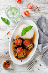 Meatballs wrapped in eggplant on a plate of rice
