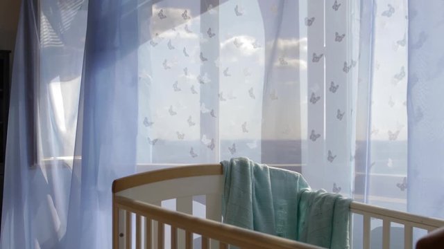 Empty baby boy room. Blue transparent curtains at decorated window in the background