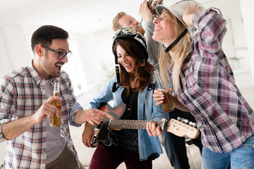 Friends having fun and partying in house and playing music