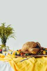 close up view of festive thanksgiving dinner table set with glasses of wine, roasted turkey and...