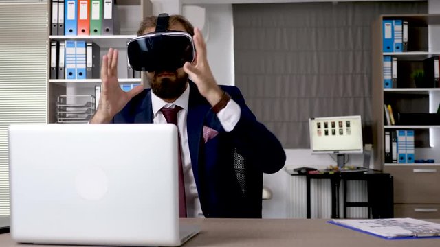 Augmented reality using VR headset - Businessman working and exploring virtual reality in start up company office. He is creating a sphere in cyberspace using his hands