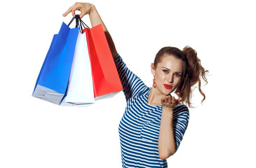 trendy woman with shopping bags on white blowing air kiss