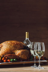 close up view of traditional roasted turkey, vegetables and glasses of wine for thanksgiving dinner...