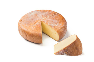Top view of cheese wheel and slice on white.
