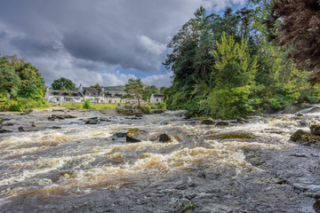 The river Dochart in spate as it crashes over the Falls of Dochart in Killin, Pertshire, Scotland.
