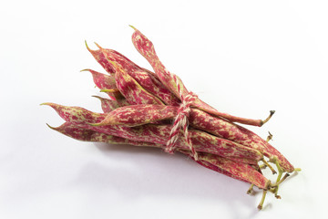 Red speckled October bean pods tied with twine, overhead view, isolated on white, horizontal aspect