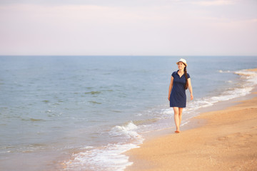 Fototapeta na wymiar woman walking on the sea beach