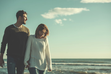 Loving young couple on a beach at autumn sunny day