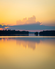 Obraz premium golden clouds and sunset in finnish lake