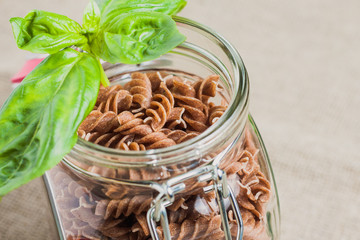 Open glass jar with fusilli paste close-up