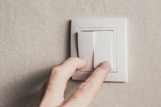 The man with his fingers turns on the light by pressing the white key