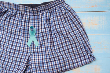 Prostate Cancer Awareness, light Blue Ribbon with male underpants on blue wooden background for...