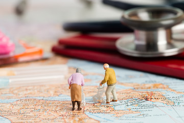 Miniature people of retirement or medical tourism concept.