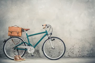 Foto op Plexiglas Retro fiets met oude lederen postbode tas en oude sneakers voor betonnen muur achtergrond. Vintage stijl gefilterde foto © BrAt82