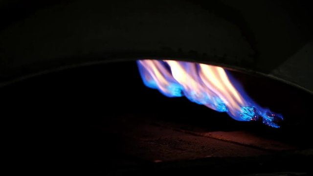 Flames in the metal and brick oven which is working with natural gas.