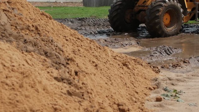Large yellow forklift construction machinery riding mud, slow motion