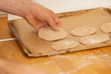 Hands putting dough on a oven plate