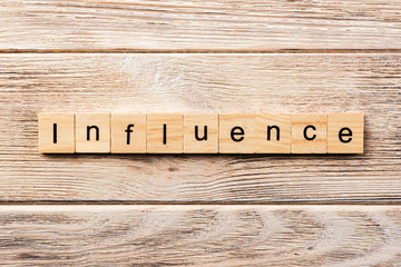 influence word written on wood block. influence text on table, concept