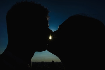 silhouette of kissing bride and groom