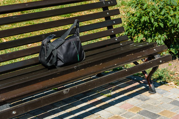 Bag on a wooden bench in city park