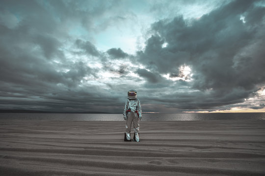 Spaceman standing alone at lake on nameless planet