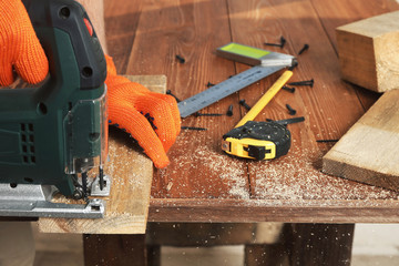sawing a board with electric jigsaw