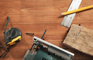 woodwork tools and electric jigsaw on the desktop