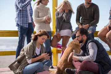 Group of friends having fun on autumn day at beach