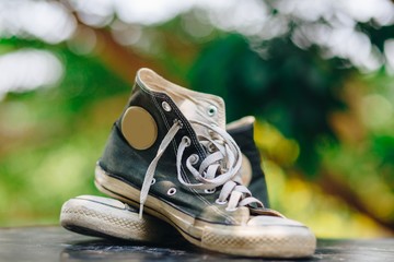 Old shoes black sneakers with bokeh background