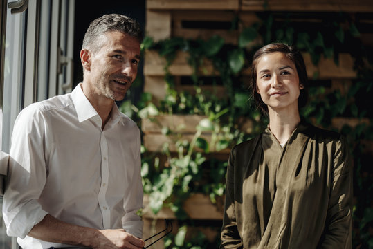 Businessman and businesswoman talking at the window
