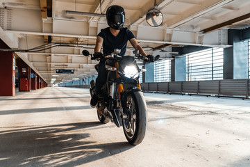 Fototapeta na wymiar Distant plan of biker riding motorcycle at parking.